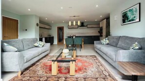 A modern living room with two grey sofas, a glass coffee table, and a patterned rug. - Whole house with parking and garden in Conwy. Pets welcome (Conwy)