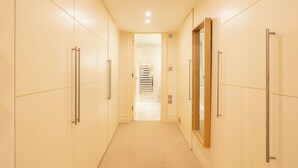 A hallway with a tiled floor leading to a bathroom with a towel rack. - Paddington 7-bed 13-guest Massive House W/patio (London)