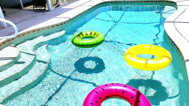 Una piscina con tres flotadores.
