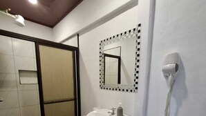 Une salle de bain avec des toilettes, un lavabo et un miroir.