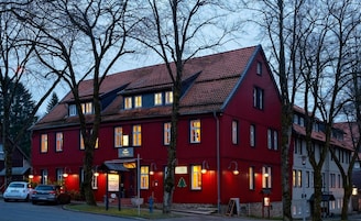 A red building with multiple windows and a sloped roof, likely a hotel or restaurant.