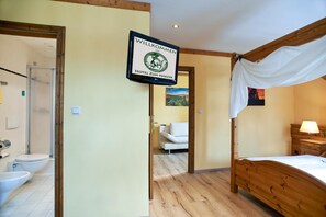 Ein Hotelzimmer mit Bett, Dusche, Toilette und einem Schild mit der Aufschrift 'WILLKOMMEN HOTEL ZUM HARZER'.