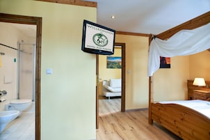 Una habitación de hotel con cama, ducha, inodoro y un cartel que dice 'WILLKOMMEN HOTEL ZUM HARZER'.