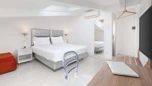 Ein modernes Schlafzimmer mit einem Bett, Nachttischen, einem Schreibtisch mit Laptop, einem Spiegel und einer Klimaanlage.
