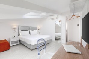 Ein modernes Schlafzimmer mit einem Bett, Nachttischen, einem Schreibtisch mit Laptop, einem Spiegel und einer Klimaanlage.