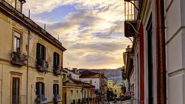 A narrow street lined with multi-story buildings, featuring balconies and awnings. - Palazzo La Via - One Bedroom (Massa Lubrense)