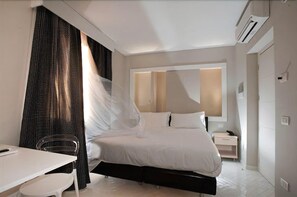 Ein modernes Hotelzimmer mit Bett, Schreibtisch und Stuhl.