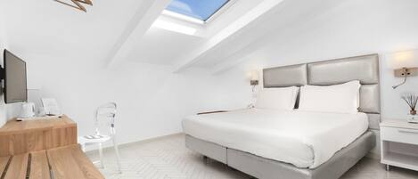 Un dormitorio moderno con tragaluces, una cama, una mesita de noche y un escritorio con una silla.