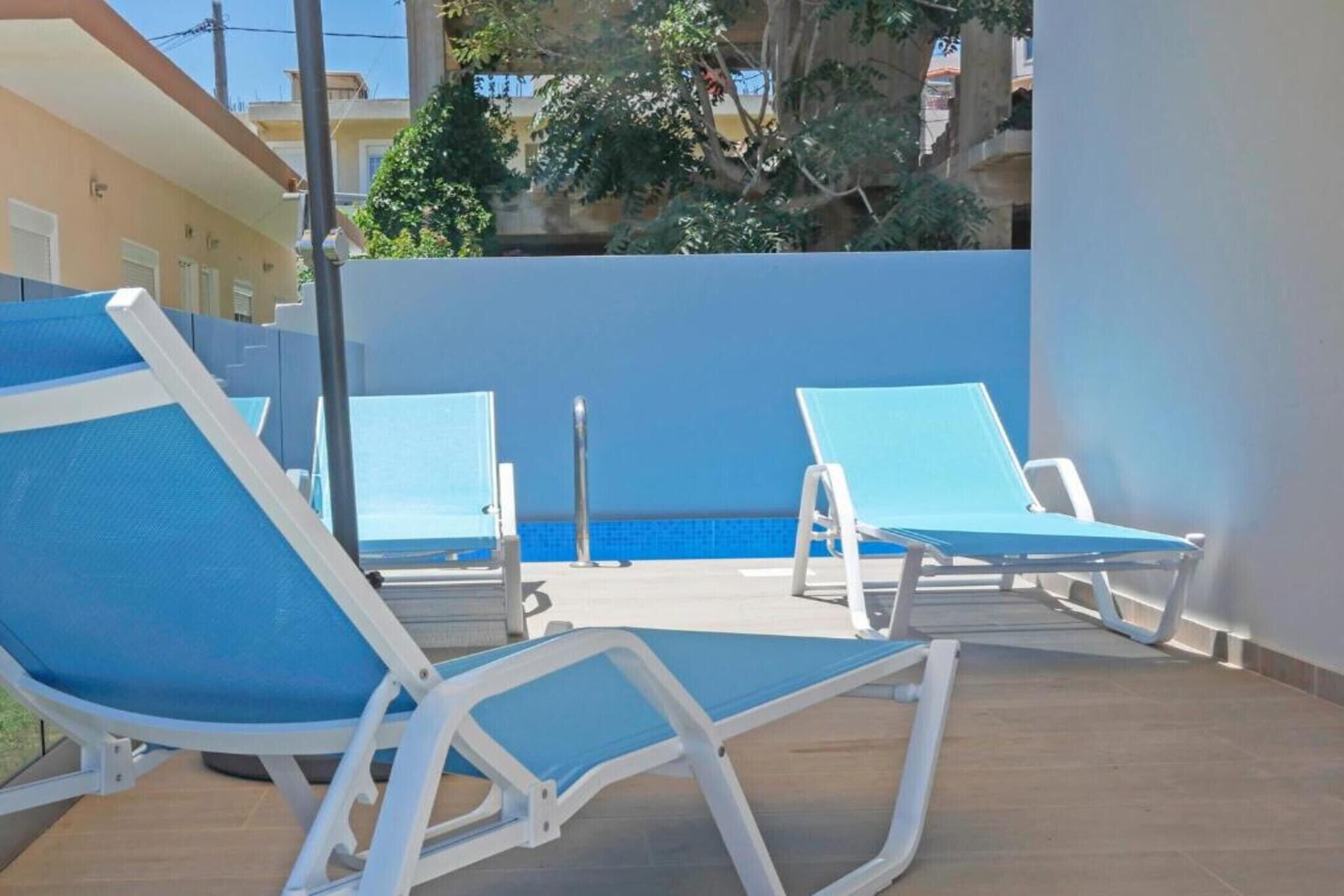 Ett område vid poolen med två solstolar och en pool.