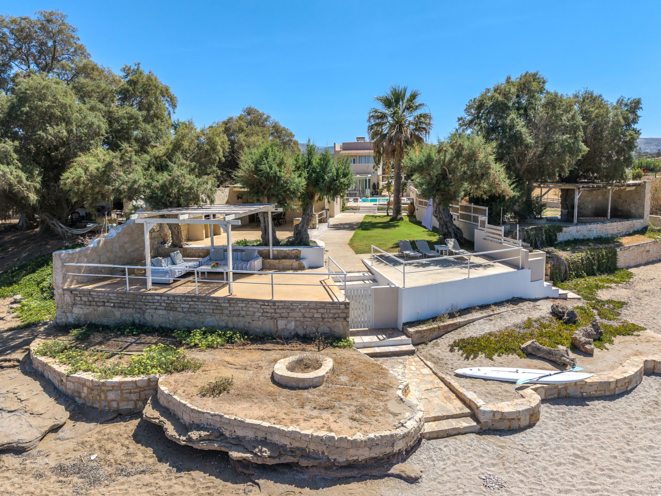 A coastal property with a patio area, outdoor seating, and a view of the sea.
