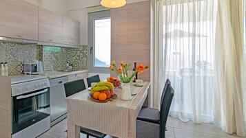 Una cocina moderna con armarios de madera, una mesa de comedor con sillas y un frutero.
