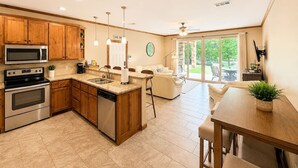 A modern kitchen with wooden cabinets, stainless steel appliances, and a central island. - Paraiso Del Rio | 3BDRM | Guadalupe River (New Braunfels)