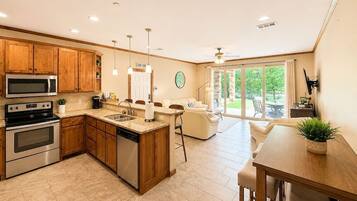 A modern kitchen with wooden cabinets, stainless steel appliances, and a central island.