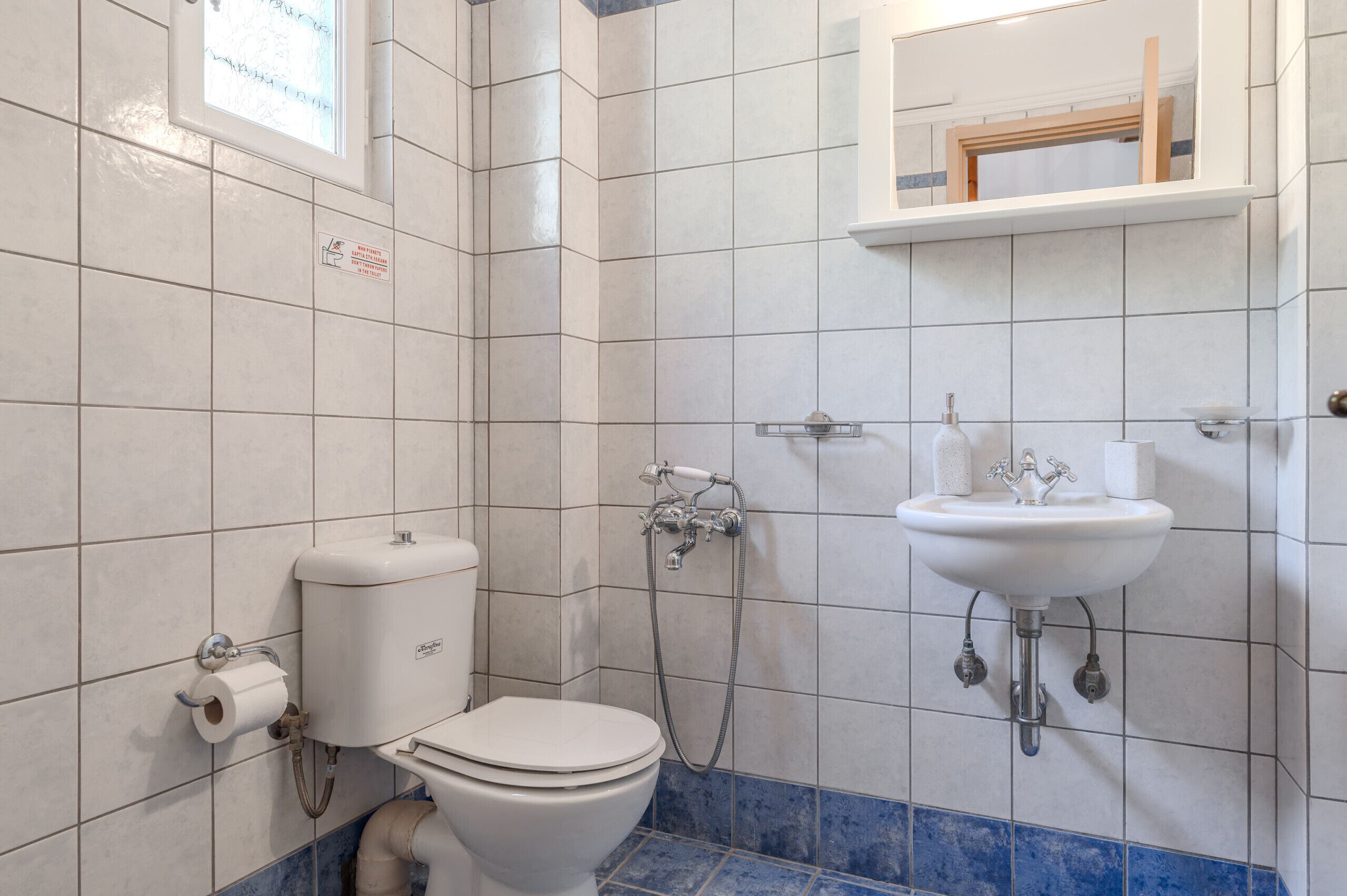 Un baño con inodoro, bidé y lavamanos.