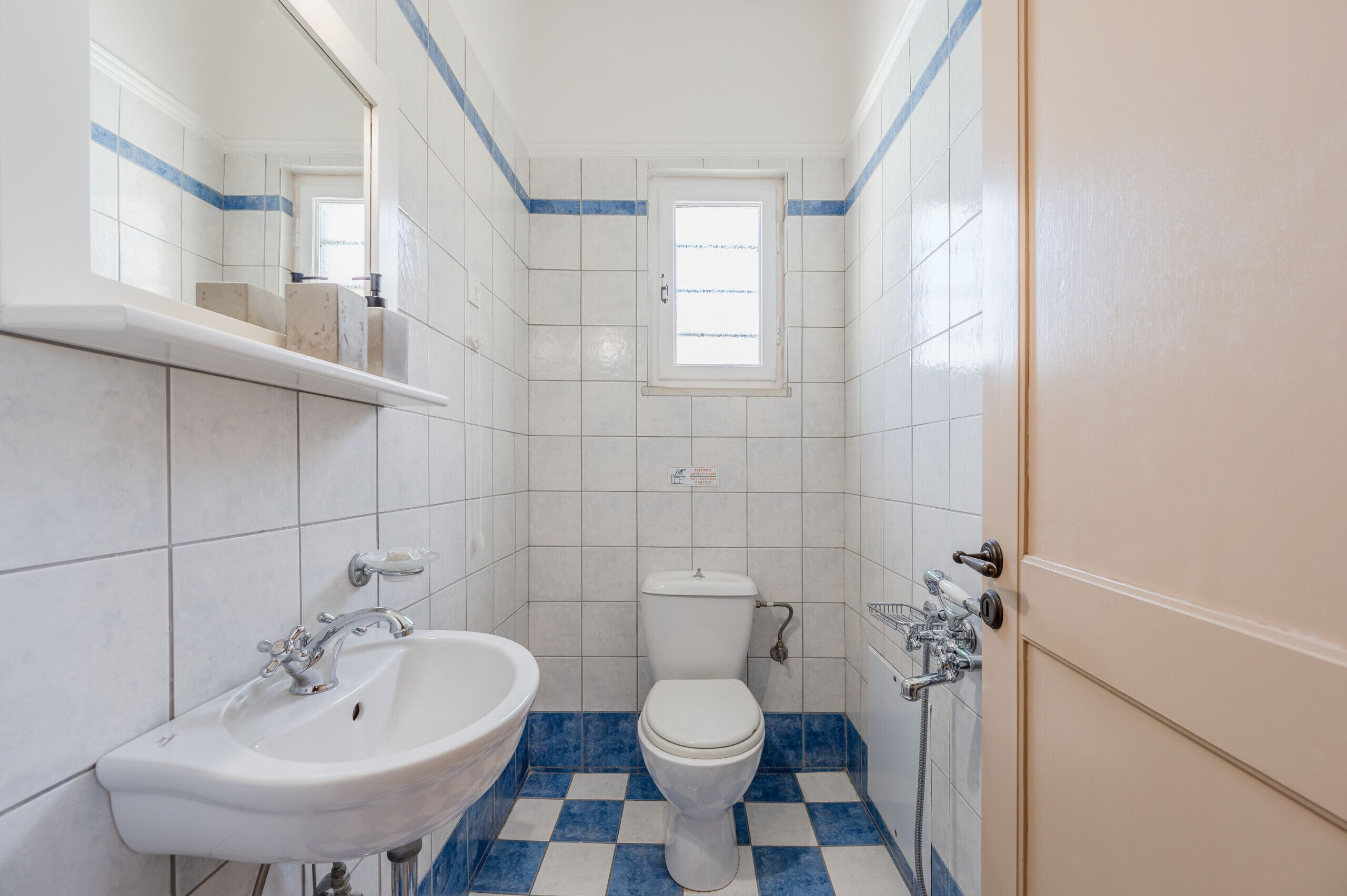 Un bagno piccolo con un lavandino bianco, un water e una finestra.