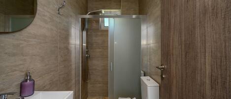 Un baño moderno con ducha, inodoro y lavabo.