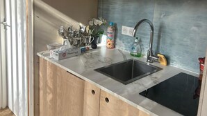 A compact kitchen with wooden cabinets, a sink, and a countertop.