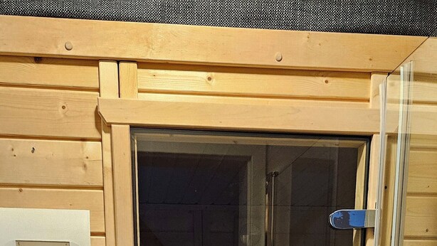 A sauna room with a glass door, wooden walls, and a control panel on the wall. - Alpine Soul (Feldberg) - Terrace (Feldberg (Schwarzwald))