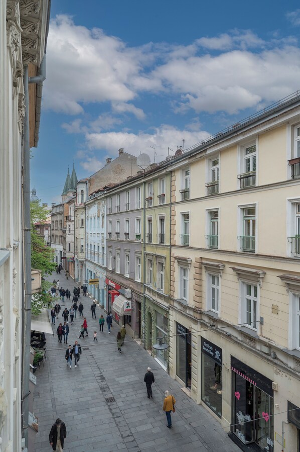 A pedestrian street lined with multi-story buildings, some with balconies and storefronts.
