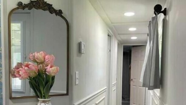 A hallway with a marble console table, a vase of pink flowers, a large mirror, and a tiled floor. - 2 BM/French Country Style DPLX (Davenport)