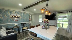 A modern kitchen with a marble island, pendant lighting, and a view of the outdoors. - 2 BM/French Country Style DPLX (Davenport)