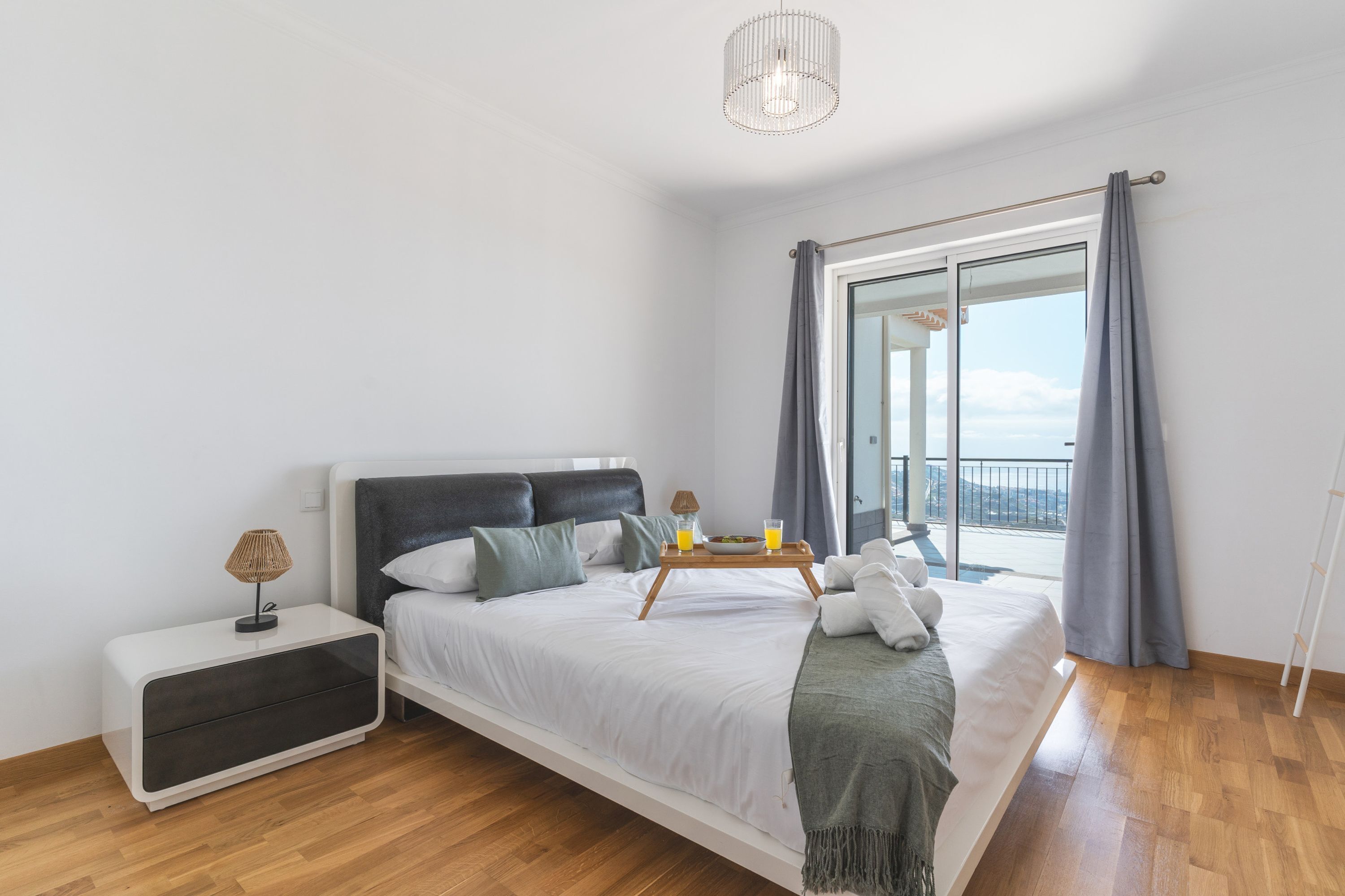 Un dormitorio moderno con cama, mesita de noche y vistas al exterior.