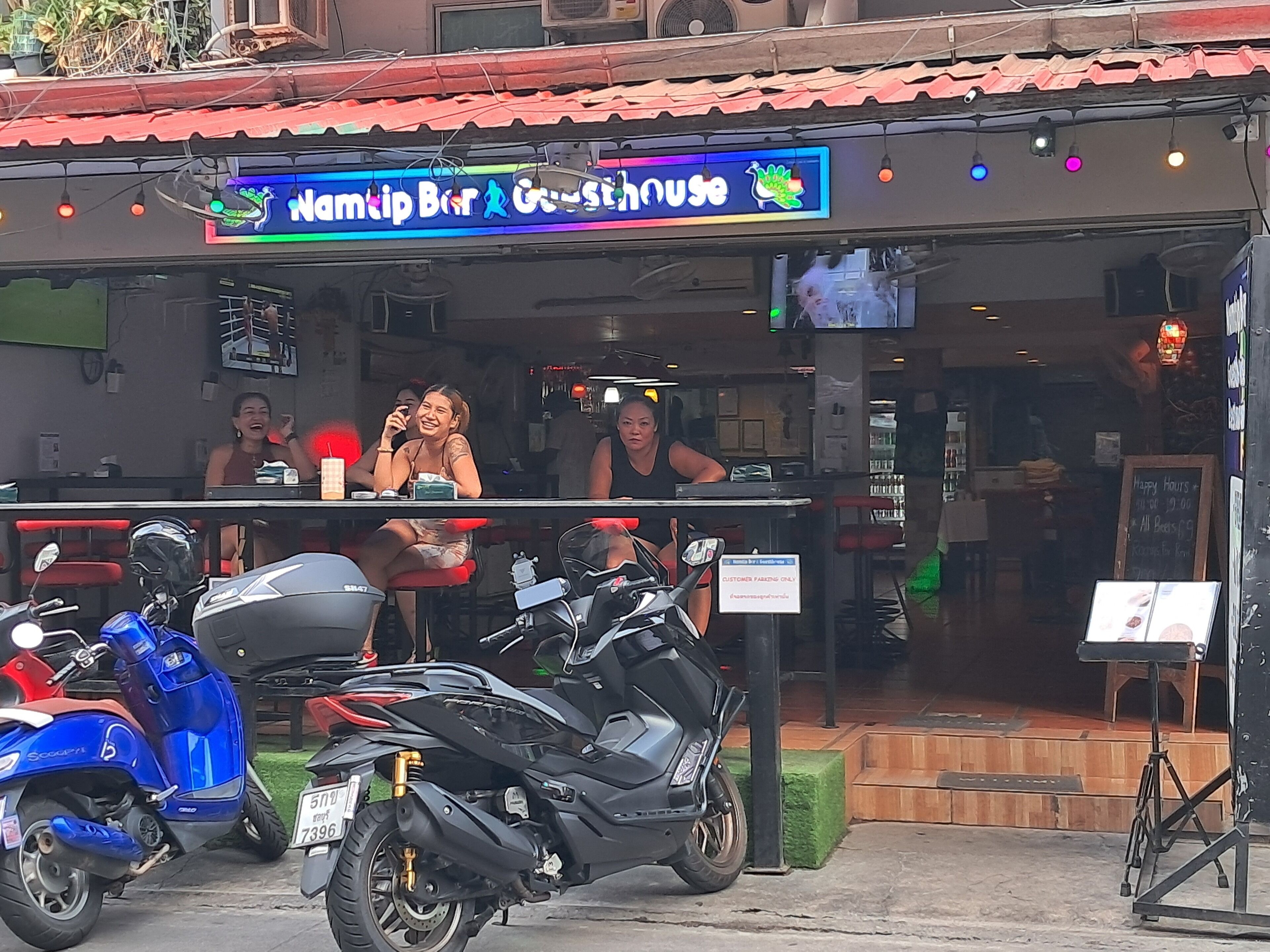 A restaurant named "Namtip Bar & Guesthouse" with outdoor seating and a stage.
