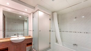 Een moderne badkamer met een grote spiegel, een wastafel en een douchehoek.