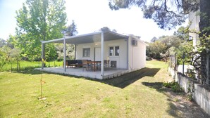A modern, single-story house with a covered patio and a small garden area. - Zennova 29 Vourvourou Garden House (Vourvourou)