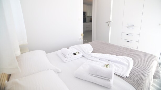 A hotel room with a neatly made bed, a wardrobe, and a bathroom visible through an open door. - Zennova 29 Vourvourou Garden House (Vourvourou)
