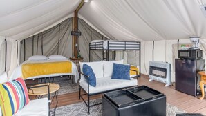A tented accommodation with a bed, sofa, and a small kitchenette. - Large tent on massive Big Rock Creek Estate! (Saint Croix Falls)