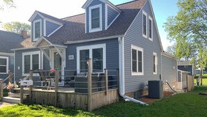 Une maison à deux étages avec une terrasse couverte, une cheminée et le numéro « 310 » sur le côté.
