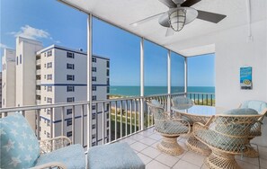 A balcony with wicker furniture and a view of the ocean. - Island Reef 703 in Fort Myers Beach (Fort Myers Beach)
