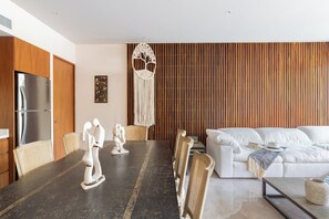 A modern living room with a sofa, dining table, and chairs. - Luxury 2Bed MT D104 By Sandy Powerful (Tulum)