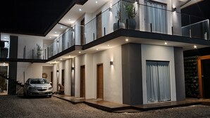 A modern two-story house with a car parked in front. - Rei dos Mares Suítes by Easy Hotéis (Ubatuba)