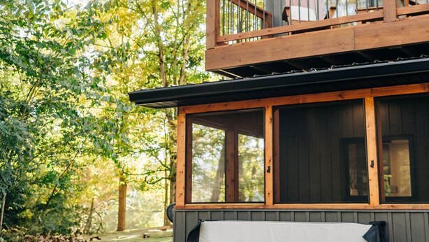 A two-story cabin with a hot tub and outdoor seating area. - Little River Retreat (Townsend)