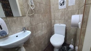 Un bagno con lavandino, water e asciugatore di mani bianchi.