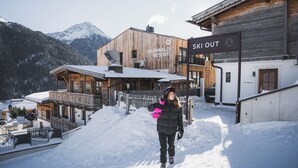 A ski resort with wooden buildings and a sign for 'Ski Out'. - Grünwald Resort Sölden (Soelden)