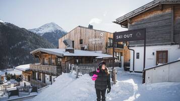 Une station de ski avec des bâtiments en bois et un panneau indiquant « Accès direct aux pistes ».