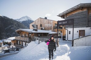 En skidort med trähus och en skylt med texten ”Skidåkning direkt från anläggningen”.