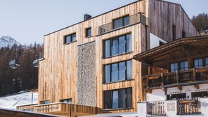 Un bâtiment moderne avec une façade en bois et de grandes fenêtres, qui ressemble probablement à un hôtel ou à un complexe touristique.
