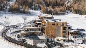 A modern ski resort with wooden buildings, a ski lift, and a snow-covered landscape. - Grünwald Resort Sölden (Soelden)