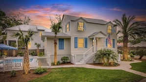 A two-story house with a white exterior, blue shutters, and a front porch.