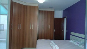 Ein Schlafzimmer mit Bett, Kleiderschrank und Tür.