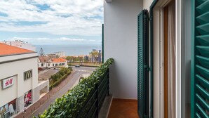 A balcony with a view of the sea, a McDonald's, and an H&M store.