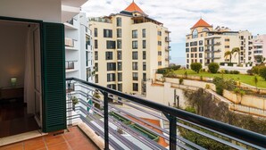 A balcony with a view of high-rise buildings, a tiled floor, and a railing. - GuestReady - Lovely experience in Funchal (Funchal)