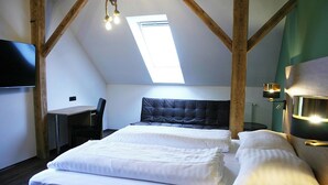 A room with a bed, a desk, and a chair. There is a skylight above the bed. - Glögglhof (Trofaiach)