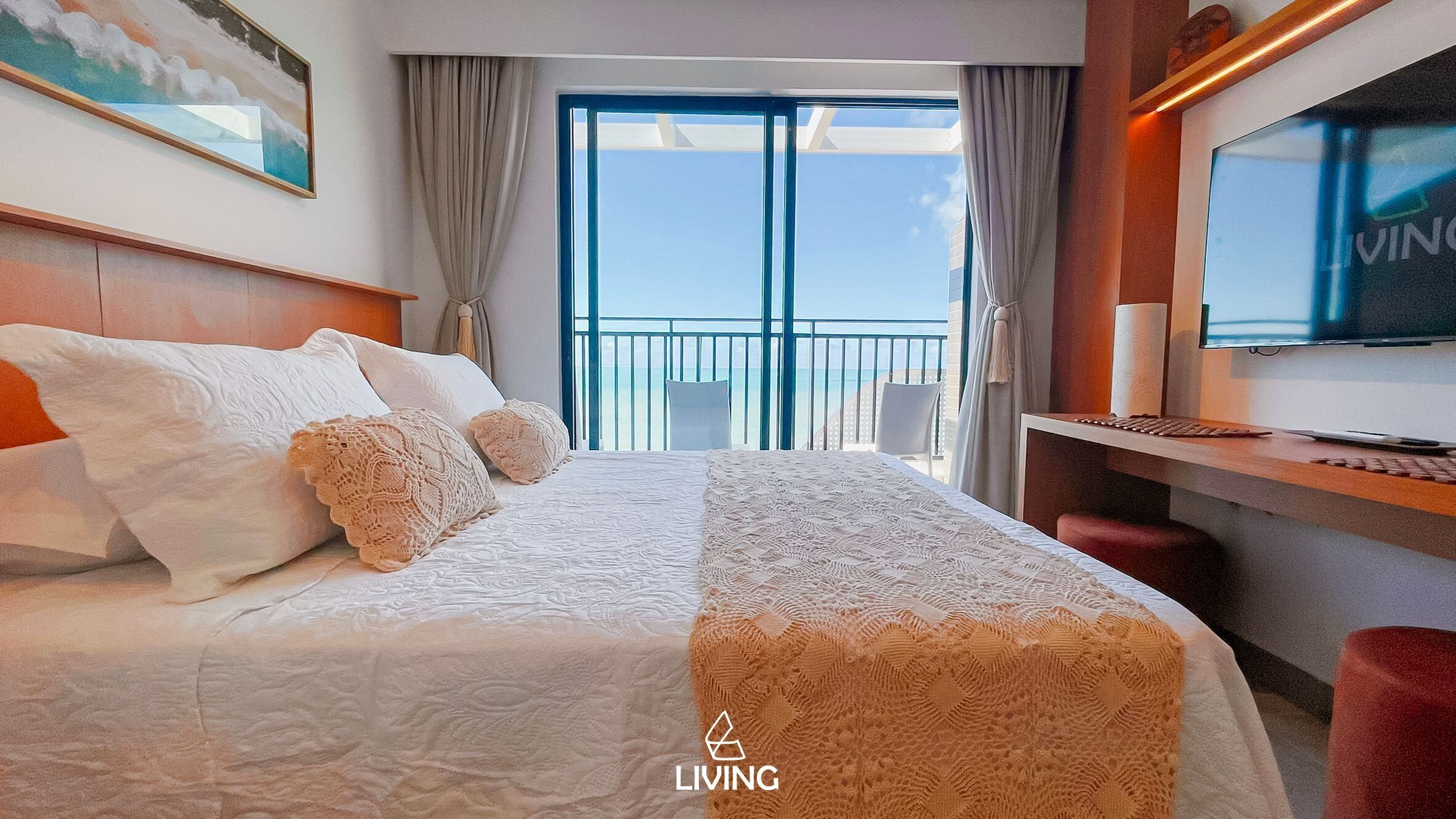 Une chambre d’hôtel avec un lit, un bureau équipé d’un ordinateur, une télévision et un balcon avec vue.