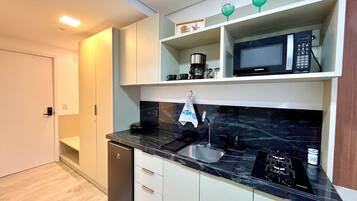 A modern kitchen with a built-in microwave, a coffee maker, and a salt container on the countertop.