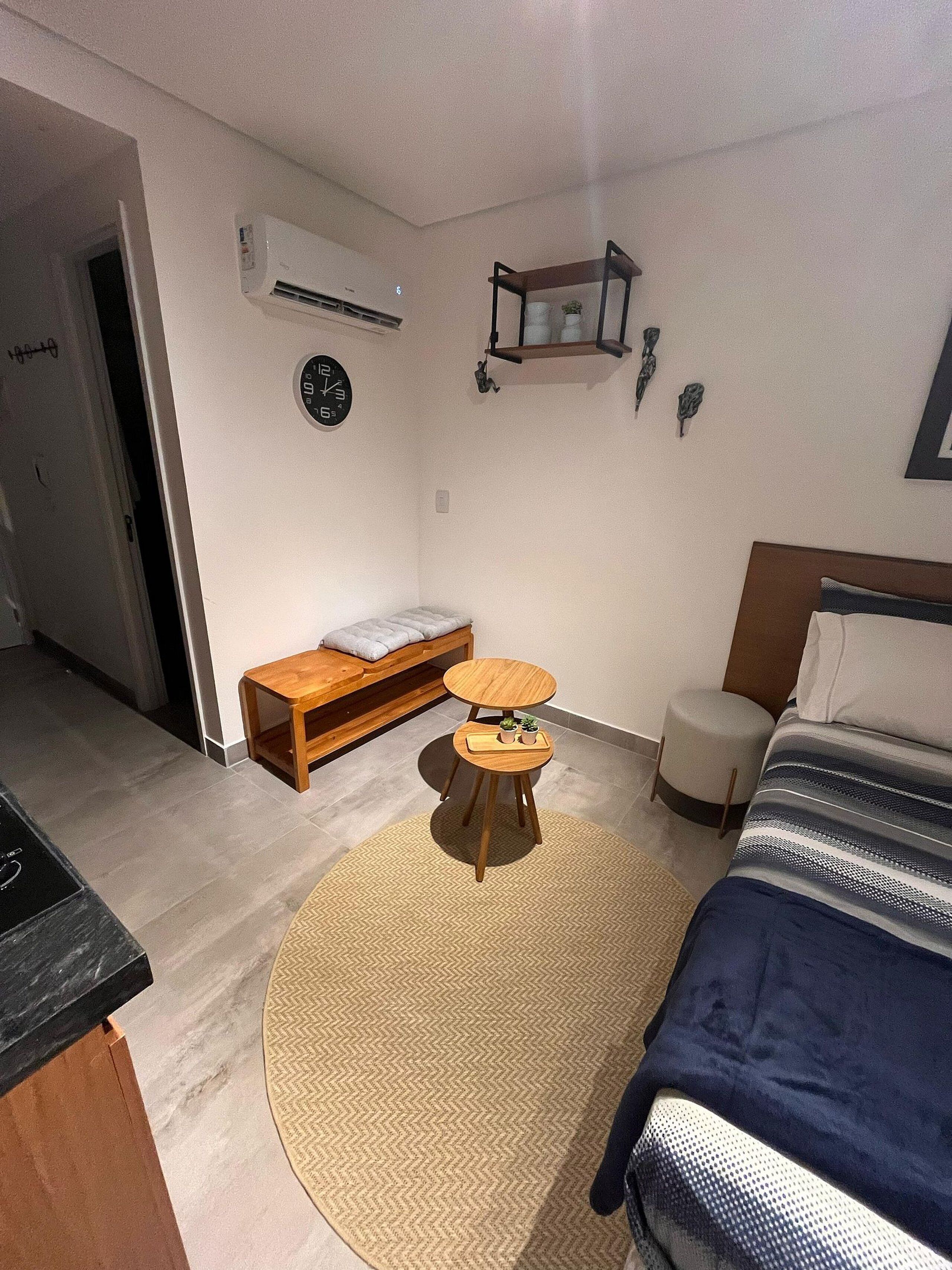 Ein Schlafzimmer mit Bett, Nachttisch, Stuhl und einem kleinen Hocker.